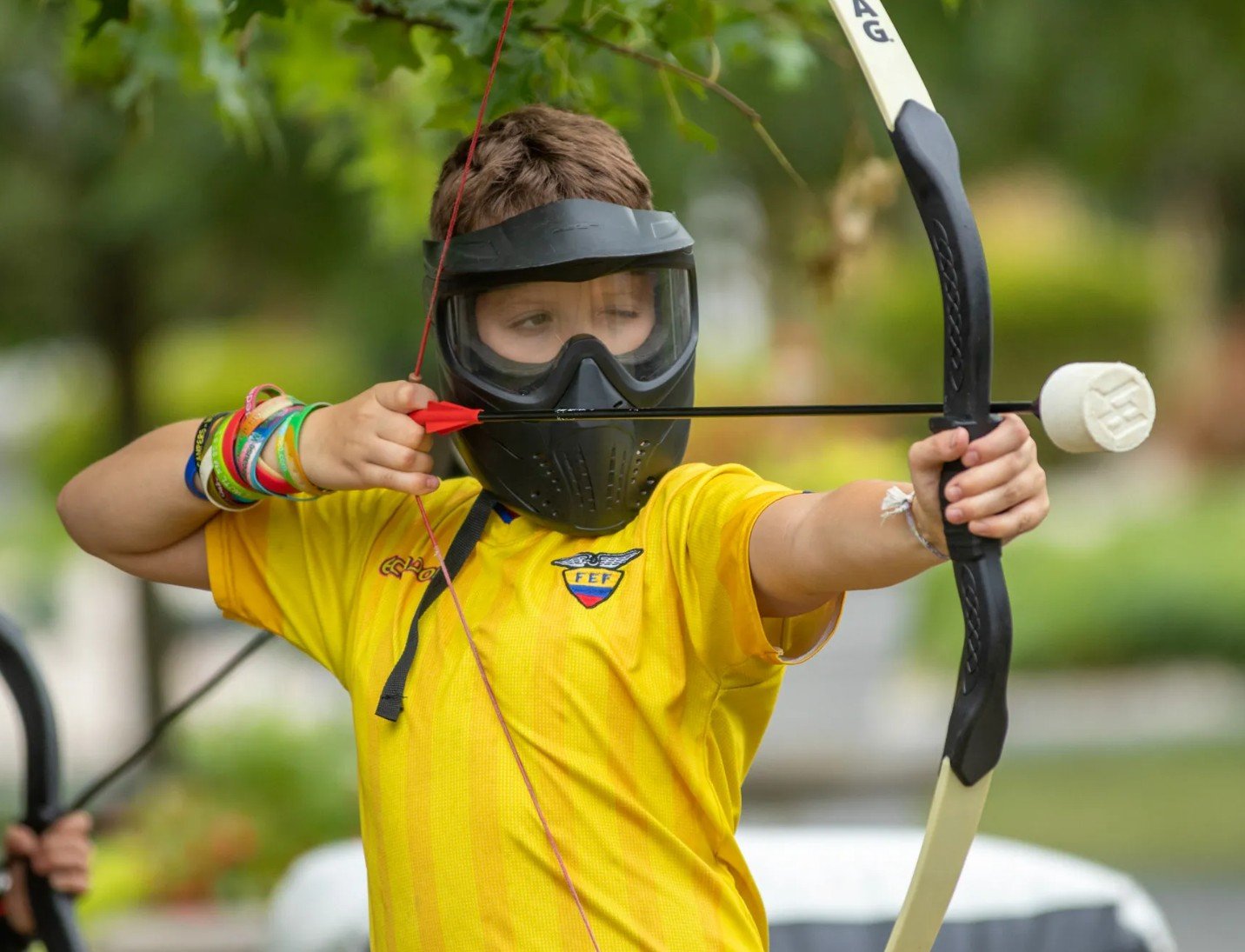 A young archer aiming a padded-tip arrow