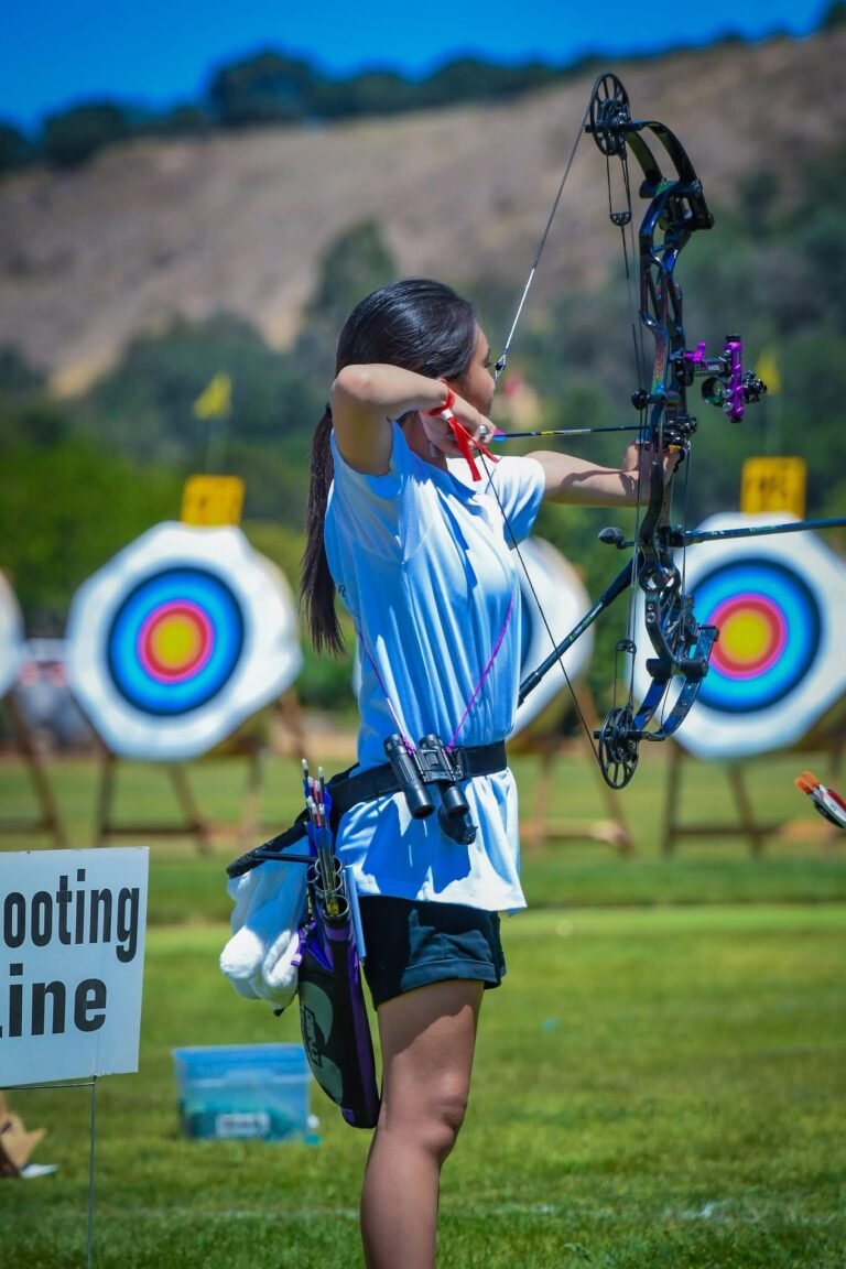 Archery student shooting outdoors with her bow.