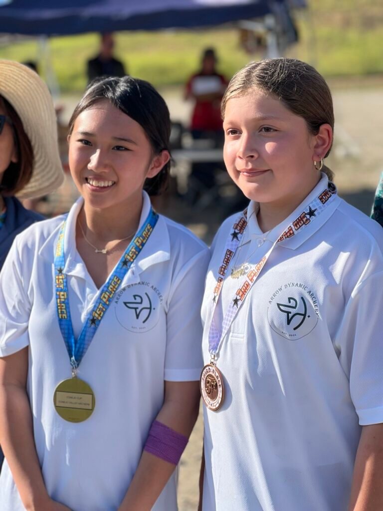 Two girls with medals hung around neck