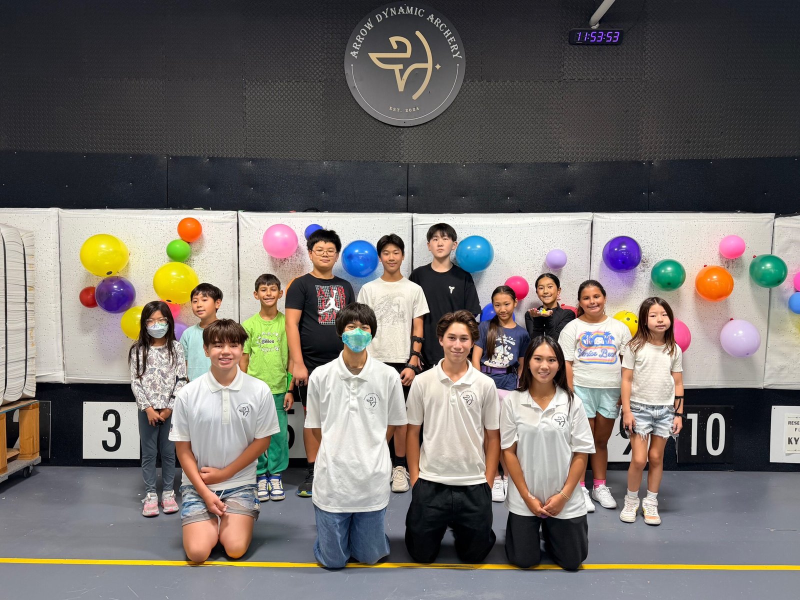Young archers shooting on the line during summer camp