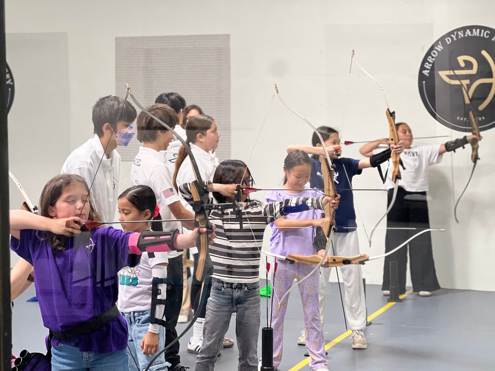 Party guests shooting on the line with a coach